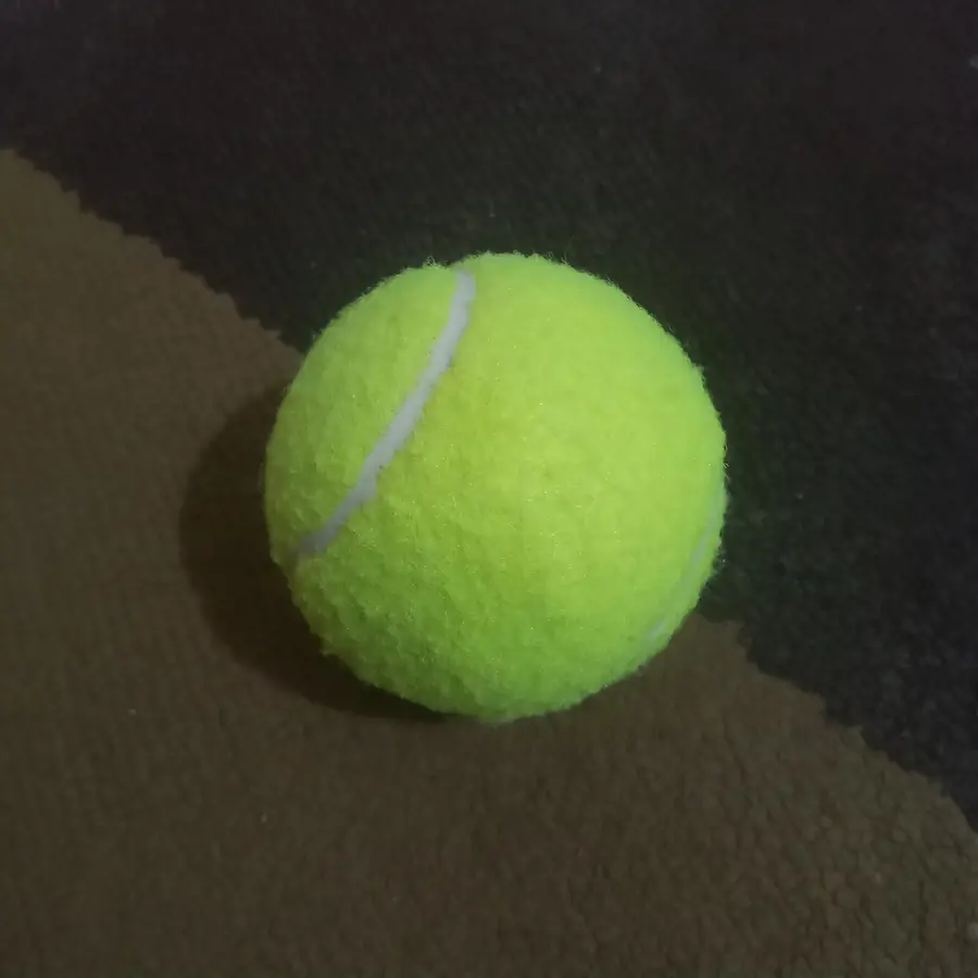 Tennisball in Großaufnahme, Filz und Naht deutlich sichtbar