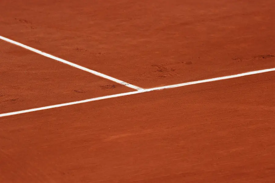 Ausschnitt der weißen Linienmarkierung auf einem Sandplatz